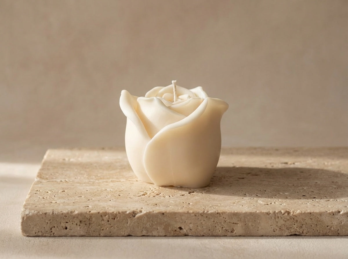 Rose-shaped candle on a stone surface with a neutral background